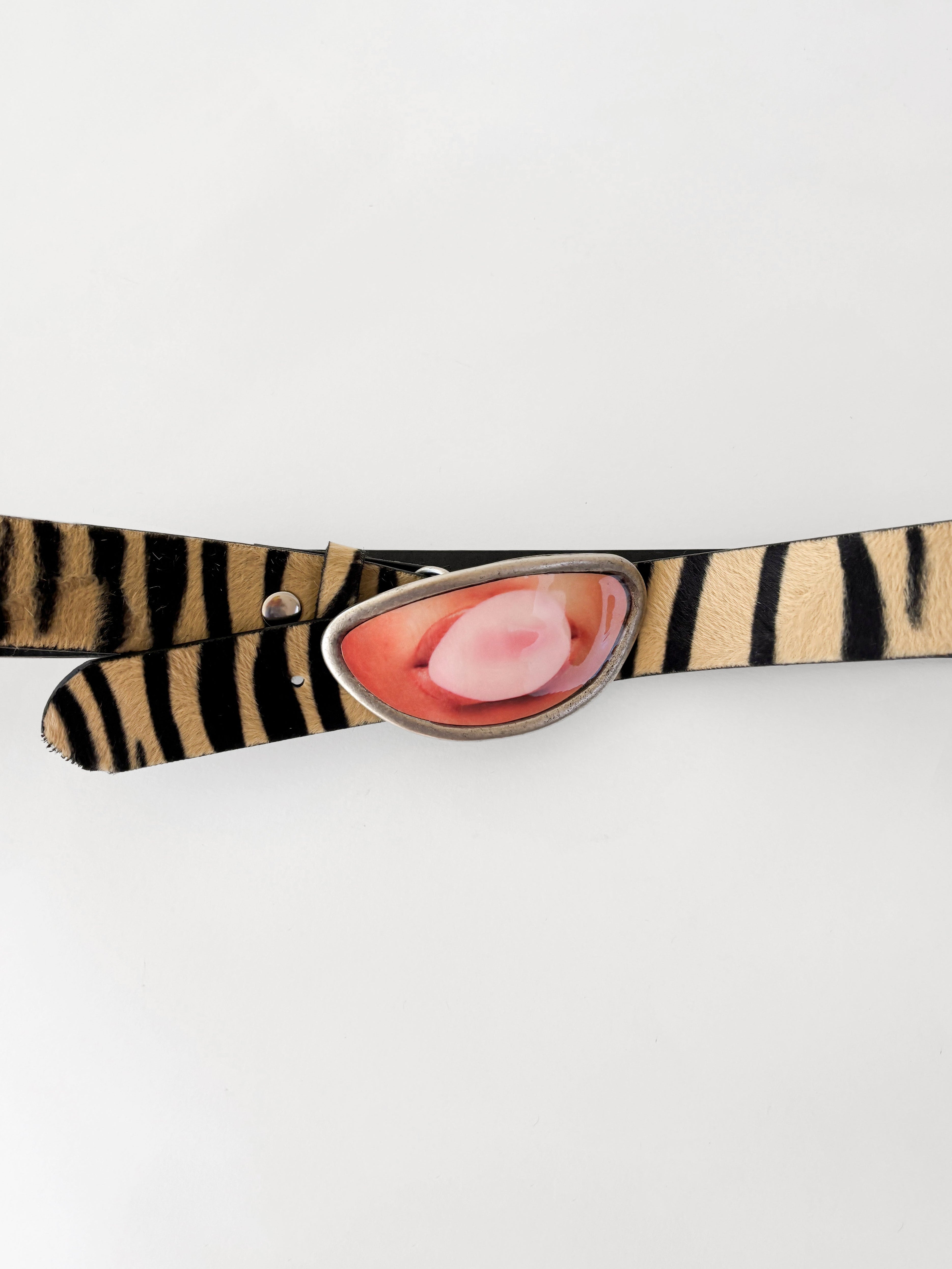 Zebra-patterned belt with a pink buckle on a white background