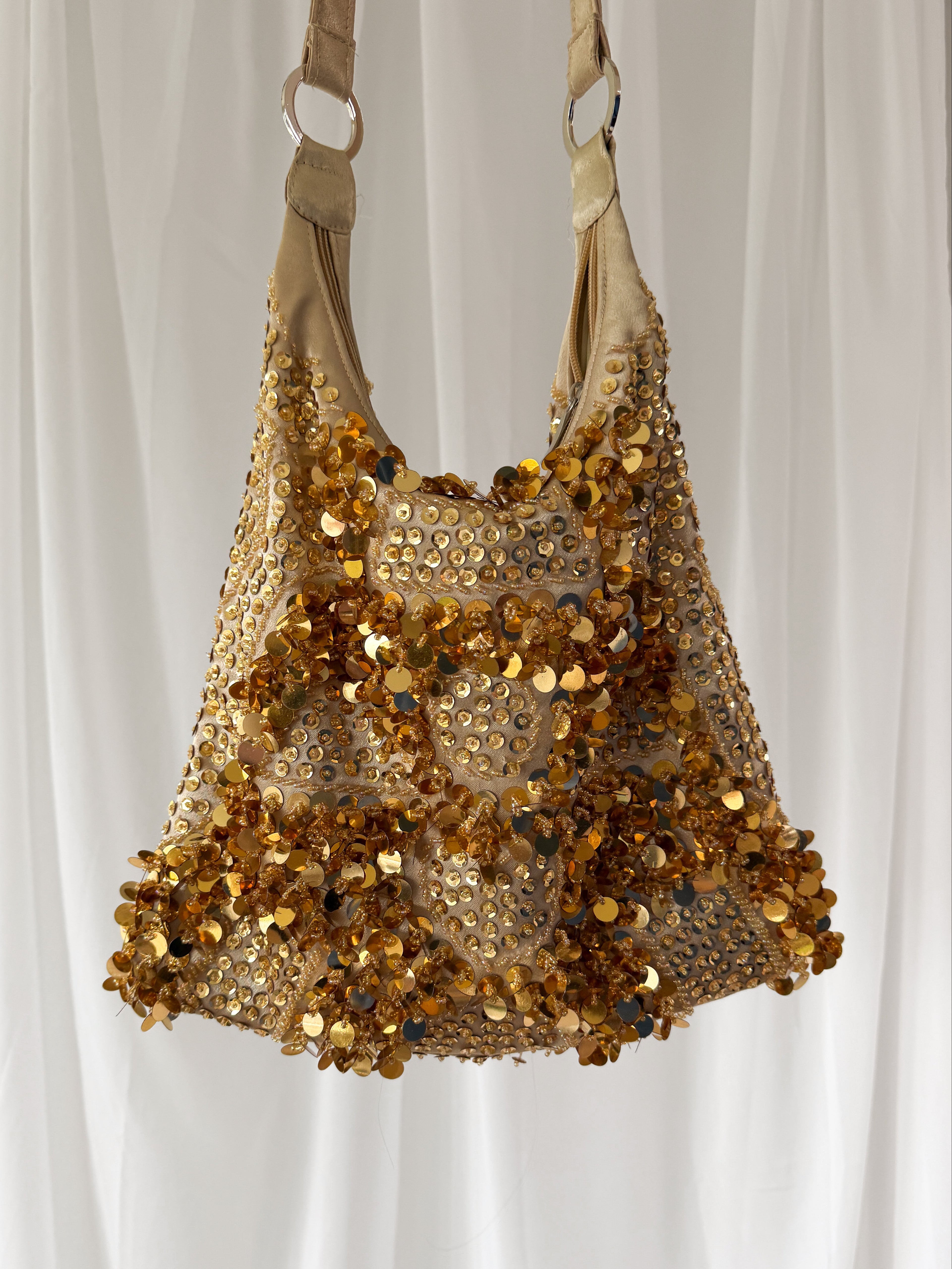 Gold sequin handbag on a white background
