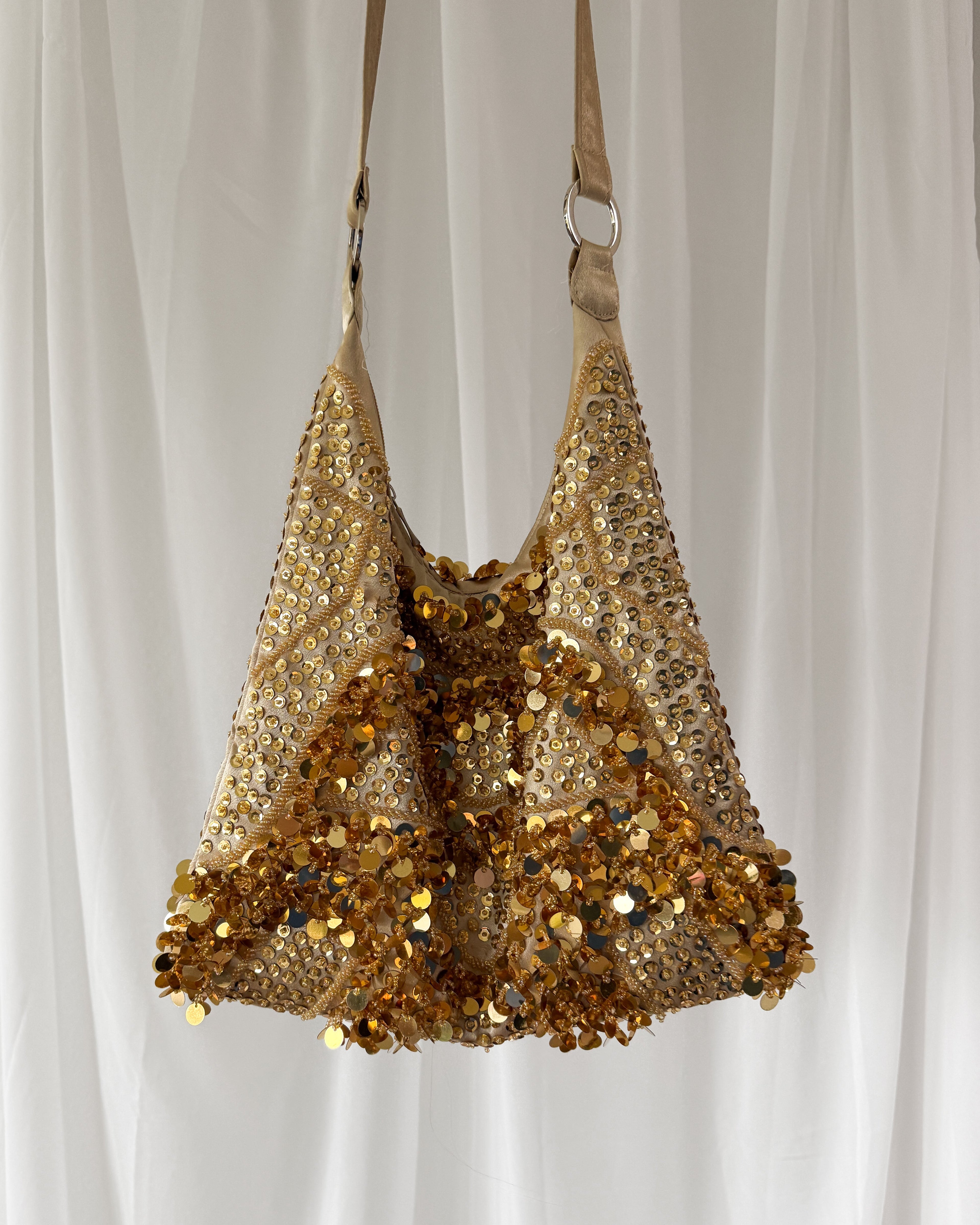 Gold sequin handbag on a white background